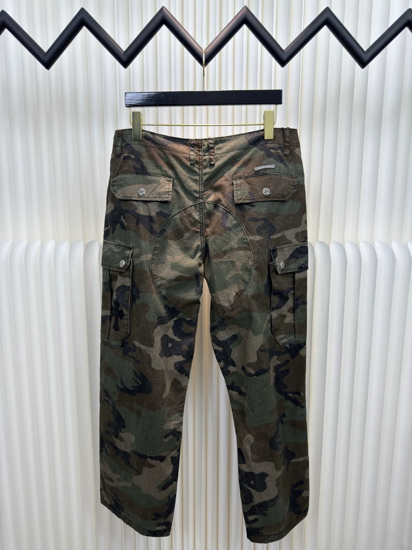 P610 Chrome Hearts camouflage leather and genuine antique silver overalls. The main fabric is dyed with fully divided camouflage. The lining is made of CH jacquard lining. The minimum order is 1000 meters. The whole pants have 14 genuine antique silver hardware. Half of the cost is in the hardware. The leather is made of imported lambskin. Hand-made edge stitching. The embroidery on the waist uses imported Tajima machine. Precision embroidery. Size 32/S 34/M 36/L